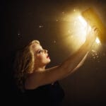 Woman reading magical book showing fantasy and magical realism blend in literature